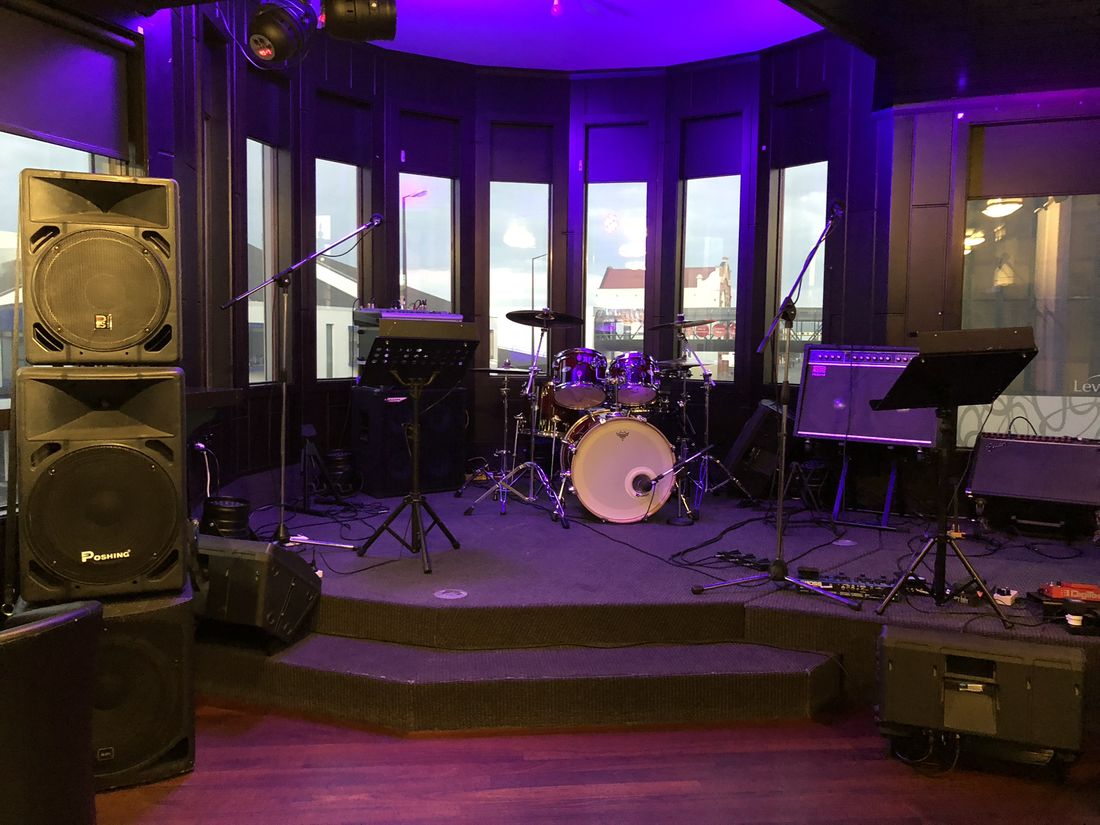 Midnight Cruise PA speakers and drum kit set up in a Southland venue